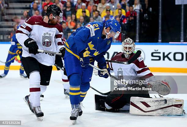 Loui Eriksson of Sweden scores his team's 3rd goal over Edgars Masalskis, goaltender of Latvia during the IIHF World Championship group A match...