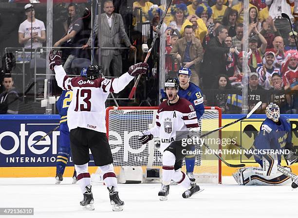 Forward Lauris Darzins of Latvia celebrates with his teammate defender Guntis Galvins after scoring a goal during the group A preliminary round ice...