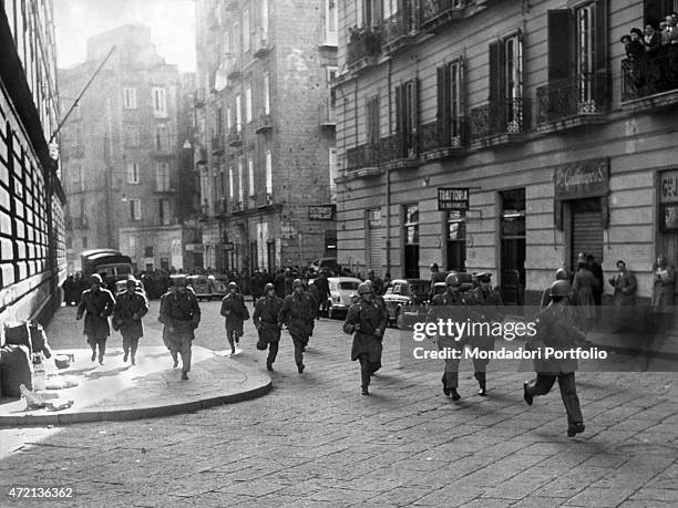 "Some policemen running in a street of Naples during a student demonstration. Naples, January 1958 "