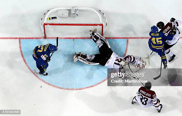 Edgars Masalskis, goaltender of Latvia covers the puck during the IIHF World Championship group A match between Latvia and Sweden at o2 Arena on May...