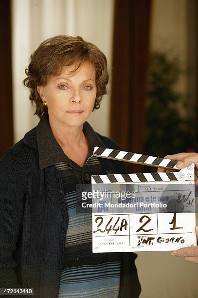 Italian actress Virna Lisi posing behind the clapper board on the set of the TV series Caterina e le sue figlie. 2004