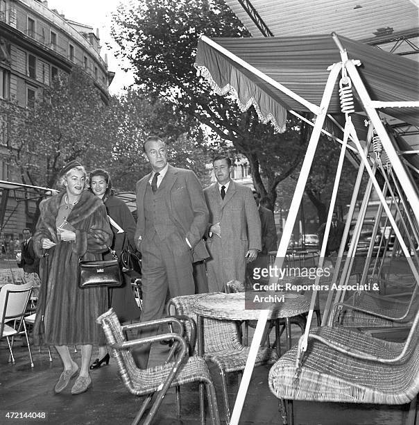 American actor Gary Cooper walking on via Veneto, in Rome, with his wife Veronica Balfe. Behind them, their daughter Maria Cooper and some other...