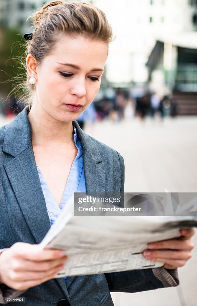 Business woman reading the newspaper in Canary Wharf