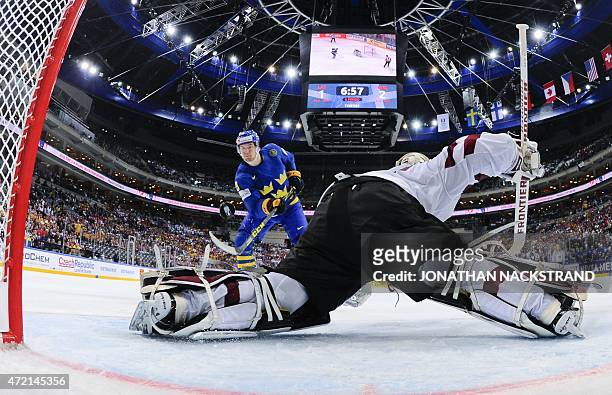 Forward Filip Forsberg of Sweden shoots to score a penalty shot past goalkeeper Edgars Masalskis of Latvia during the group A preliminary round ice...