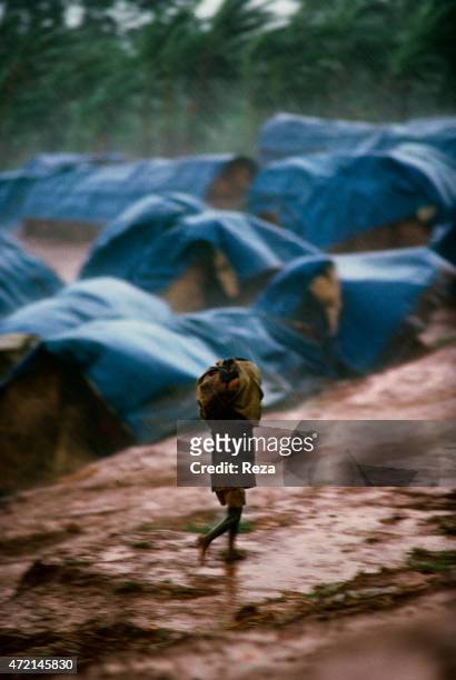 Kanague Camp, Lake Cyohoha, Rwanda. During the Rwandan Genocide, in a refugee camp, an orphan Burundian Hutu boy runs under the rain in the middle of...