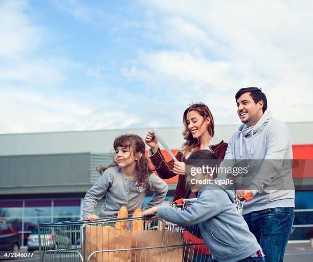 familia en el estacionamiento después de ir de compras. - carro supermercado fotografías e imágenes de stock