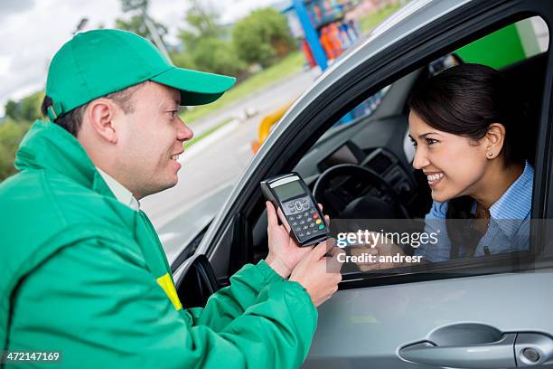 frau zahlen an der tankstelle - petrol paying stock-fotos und bilder