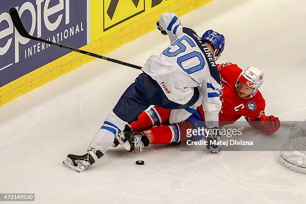 Ole-Kristian Tollefsen of Norway and Juhamatti Aaltonen of Finland battle for the puck during the IIHF World Championship group B match between...