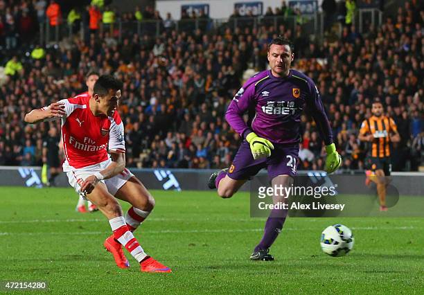 Alexis Sanchez of Arsenal beats goalkeeper Steve Harper of Hull City as he scores their third goal during the Barclays Premier League match between...