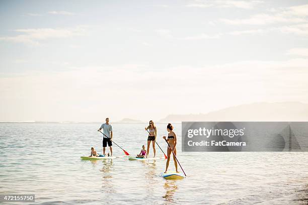 beautiful scenery when paddleboarding - fat guy on beach stockfoto's en -beelden