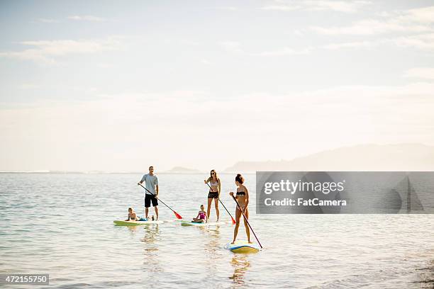 beautiful scenery when paddleboarding - hawaii vacation and parent and teenager stock pictures, royalty-free photos & images