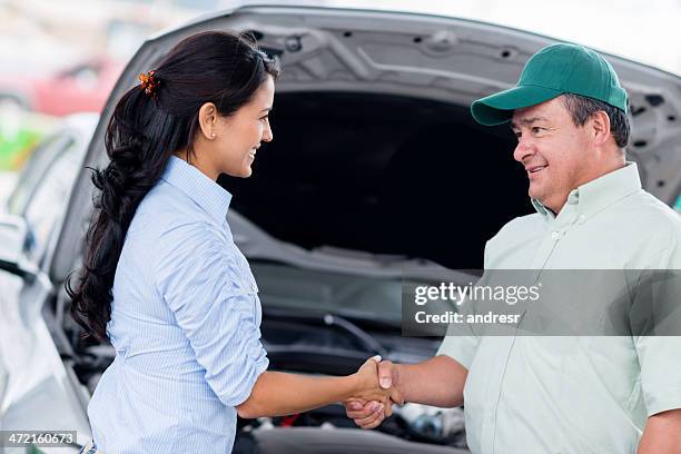 frau mechaniker handshaking mit - happy client by broken car stock-fotos und bilder