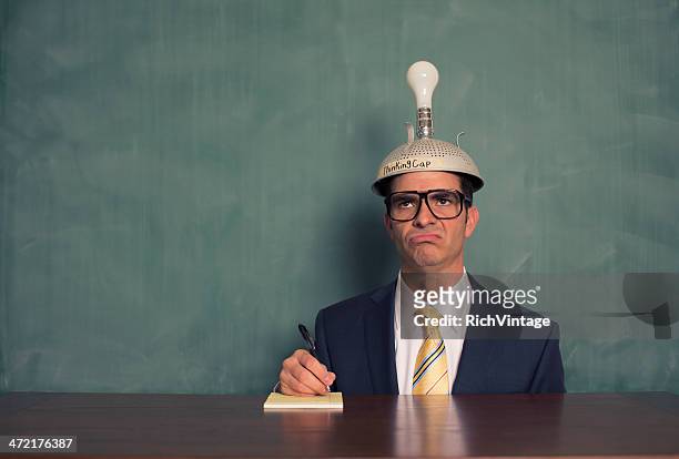 confus homme d'affaires portant bonnet de penser au bureau non éclairé - ignorance photos et images de collection