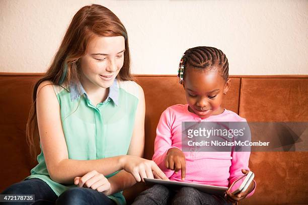 baby sitter playing with preschooler using tablet mobile phone - nanny stock pictures, royalty-free photos & images