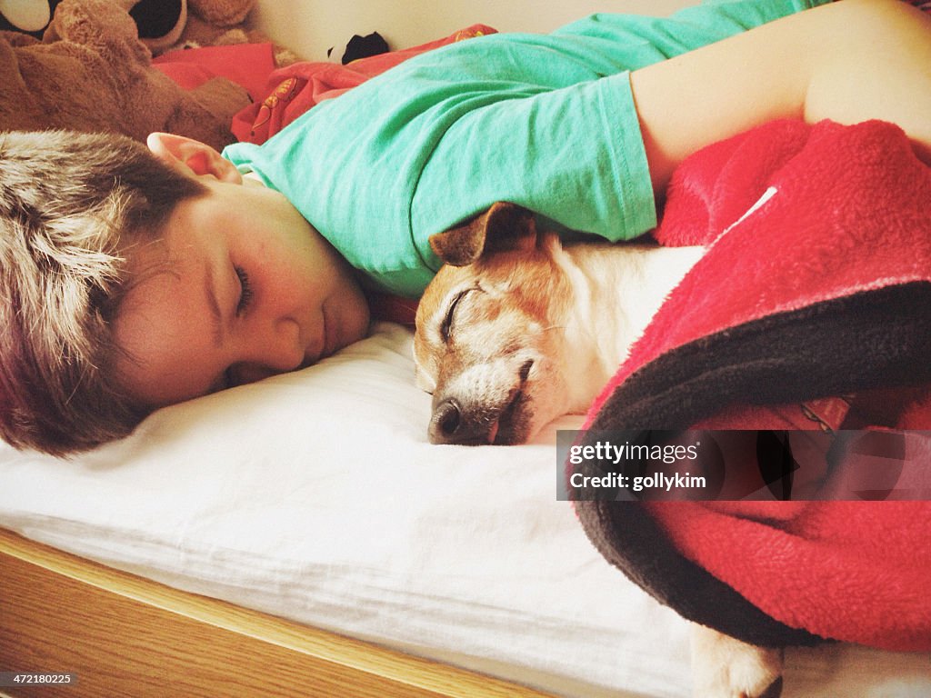 Boy sleeping with dog