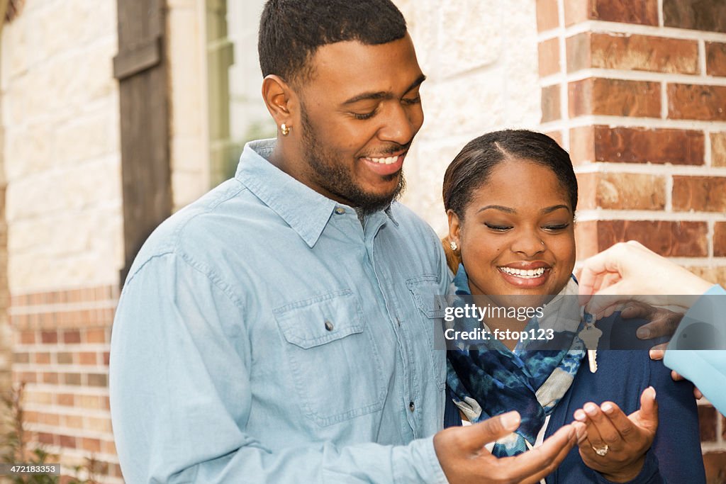 Real Estate: African descent couple buys home. House key, Real Estate Agent.