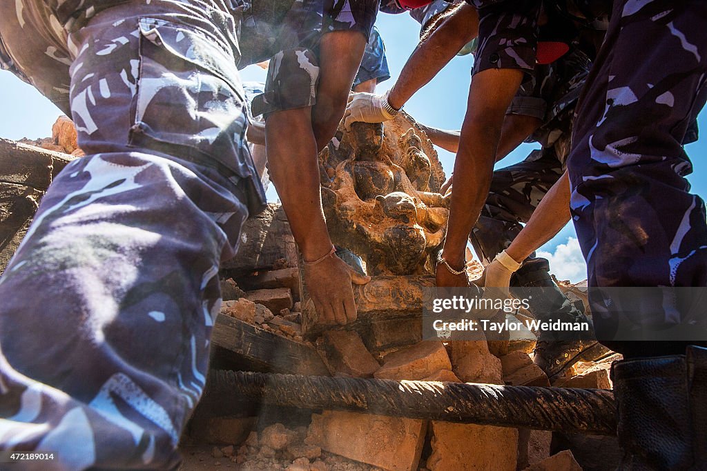 Nepali soldiers remove a statue of the God Narayan atop...