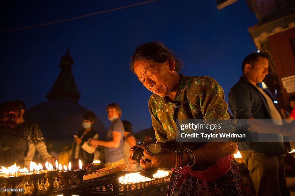 A woman sets out votive candle as she celebrates the...