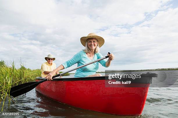 senior couple in canoe on water - seniors canoeing stock pictures, royalty-free photos & images