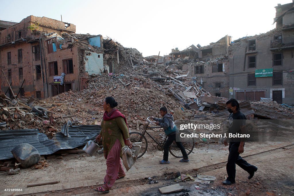 People walk past the ruins in Bhaktapur. A major 7.9...