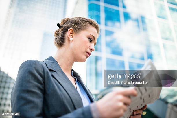 business woman reading the newspaper in canary wharf - blank newspaper stock pictures, royalty-free photos & images
