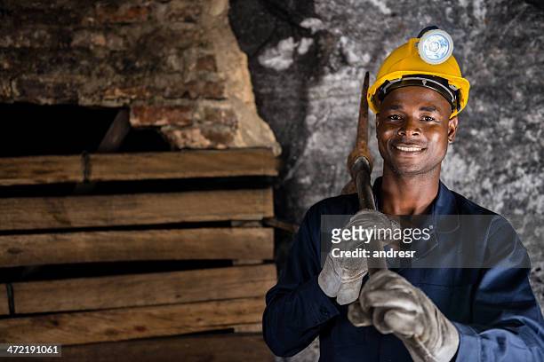 miner holding a pick axe - mijnwerker stockfoto's en -beelden