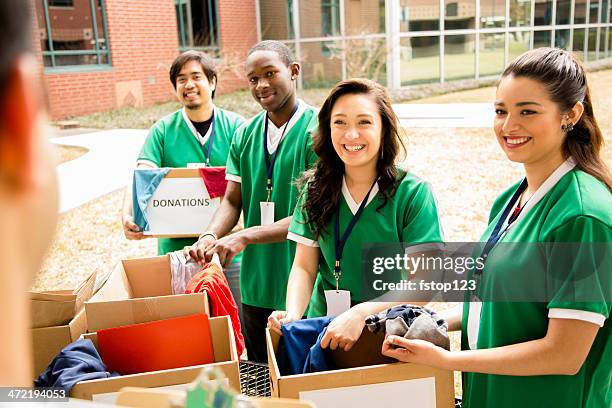 freiwillige: college-studenten, die kleidung spenden sammeln für die gemeinschaft. - charity education stock-fotos und bilder