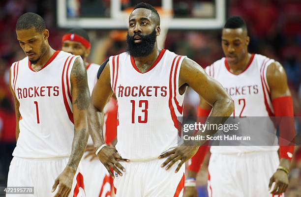 Trevor Ariza, James Harden and Dwight Howard of the Houston Rockets walk to the bench against the Los Angeles Clippers during Game One in the Western...