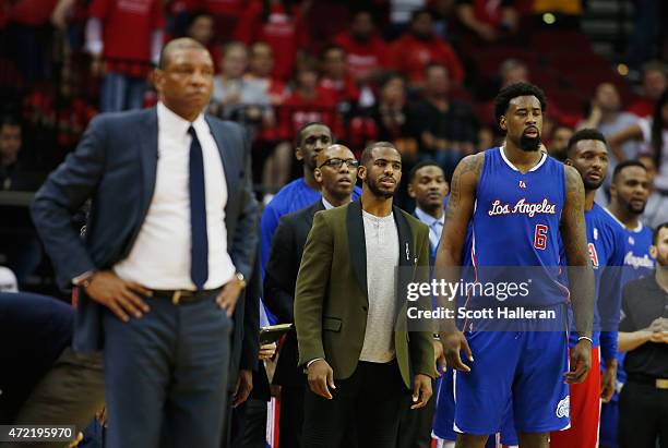 Chris Paul of the Los Angeles Clippers waits alongside his coach Doc Rivers and DeAndre Jordan near the bench late in their game against the Houston...