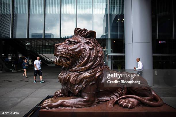 Pedestrians walk past one of the HSBC Holdings Plc lion statues at the bank's headquarters in the Central district of Hong Kong, China, on Monday,...