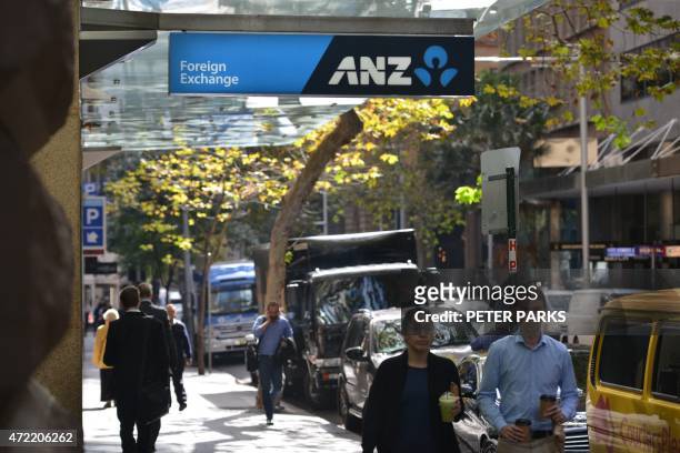 People walk past a branch of the Australia and New Zealand Banking Group in Sydney on May 5, 2015. ANZ posted a modest first half net profit rise of...