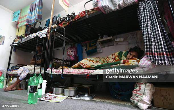 Mubarak, a labourer from Bangladesh rests in his bedroom at a private camp housing foreign workers in Doha, on May 3, 2015. The Qatari government has...