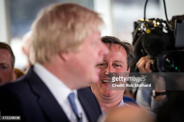 Prime Minister David Cameron laughs as Mayor of London Boris Johnson speaks to staff at Utility Warehouse on May 5, 2015 in Hendon, England....