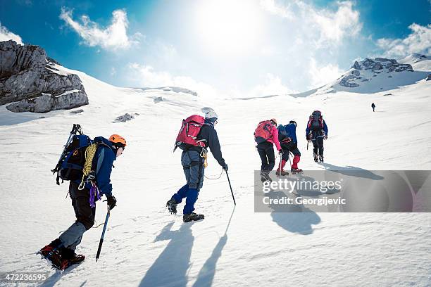 mountaineering - team climbing up to mountain top stockfoto's en -beelden