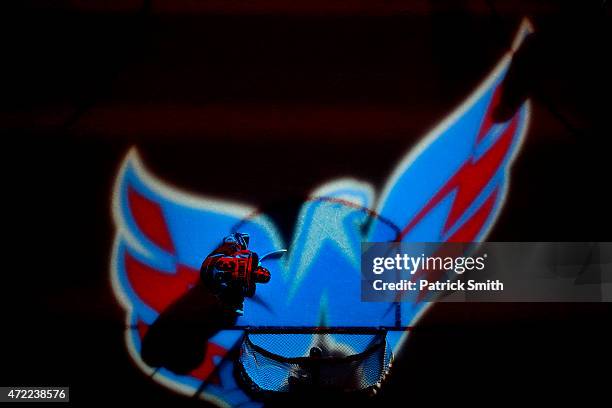 Goalie Henrik Lundqvist of the New York Rangers is illuminated by the Washington Capitals logo in Game Three of the Eastern Conference Semifinals...