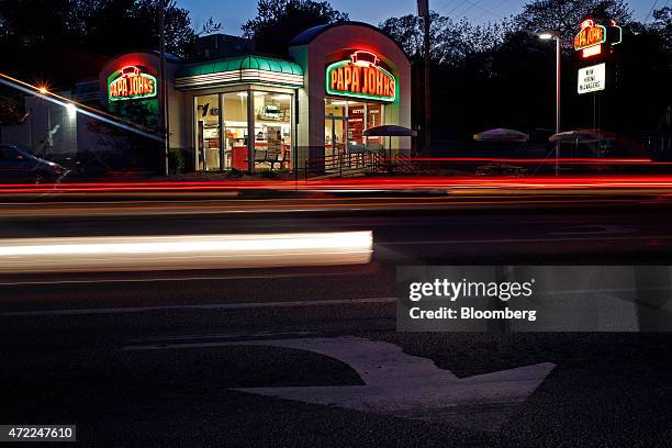 Evening traffic streaks past a Papa John's International Inc. Restaurant in Louisville, Kentucky, U.S., on Friday, May 1, 2015. Papa John's is...