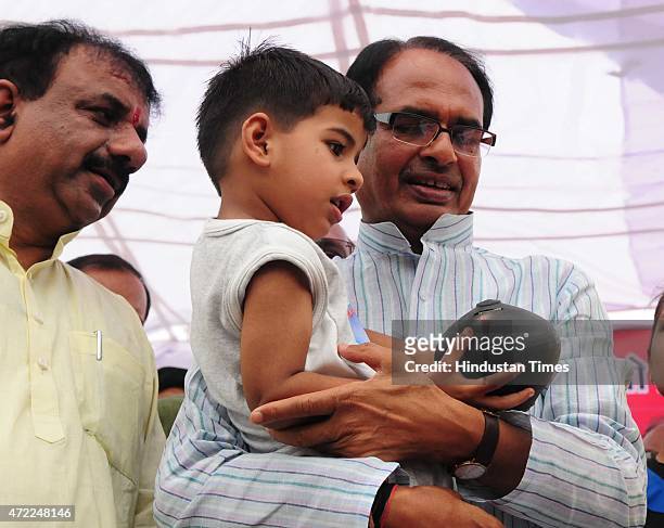 Three and half year old Prateek Soni handing over his piggy bank to chief minister Shivraj Singh Chouhan for Nepal earthquake victims relief fund, on...