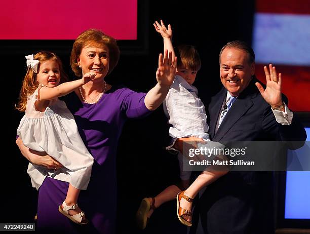 Former Arkansas Governor Mike Huckabee and his wife, Janet, hold their grandchildren Scarlet Sanders and Chandler Huckabee after announcing his...