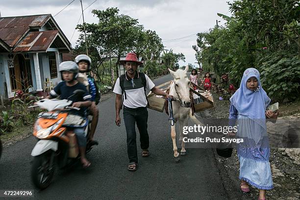 Year old Ridwan Sururi accompanied by his daughter Indriani Fatmawati and Luna, a horse used as mobile library walk to Miftahul Huda Islamic...