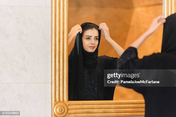 traditionell gekleideten emiratischen frau anpassen hijab in gold eingerahmter spiegel - dubai spa stock-fotos und bilder