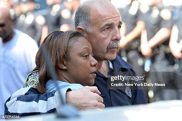 Cops hug as they line up as the body of police officer Brian Moore leaves Jamaica Hospital. He was shot in the face two days ago,allegedly, by...