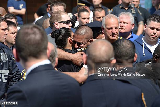 Cops hug as the body of Police Officer Brian Moore leaves Jamaica Hospital. He was shot in the face two days ago,allegedly, by Demetrius Blackwell,...