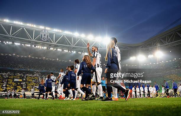 Teams and player escors walk on to the pitch prior to the UEFA Champions League semi final first leg match between Juventus and Real Madrid CF at...