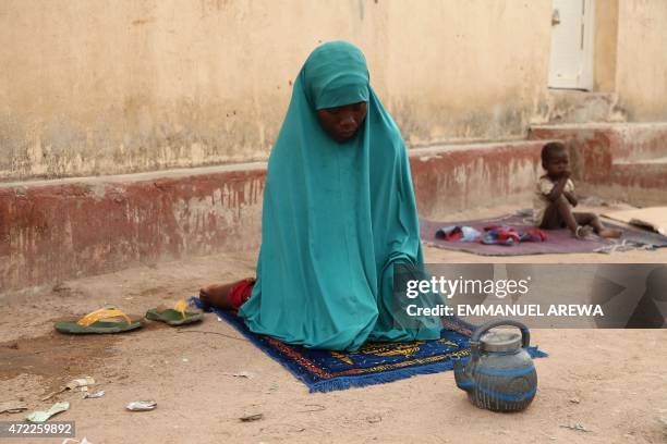 Woman rescued by Nigerian soldiers from Islamist militants Boko Haram at Sambisa Forest prays at the Malkohi refugee camp in Yola on May 5, 2015....