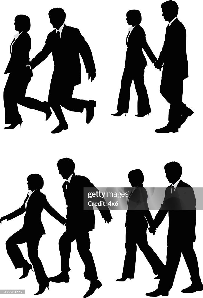 Casal de negócios andando e pulando segurando as mãos