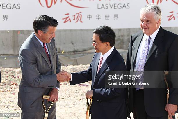 Nevada Gov. Brian Sandoval shakes hands with Chairman and CEO of the Genting Group K.T. Lim as Clark County Commissioner Steve Sisolak looks on...