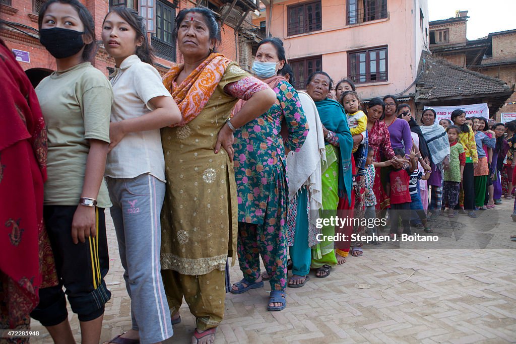 People line up to receive food in Bhaktapur. A major 7.9...