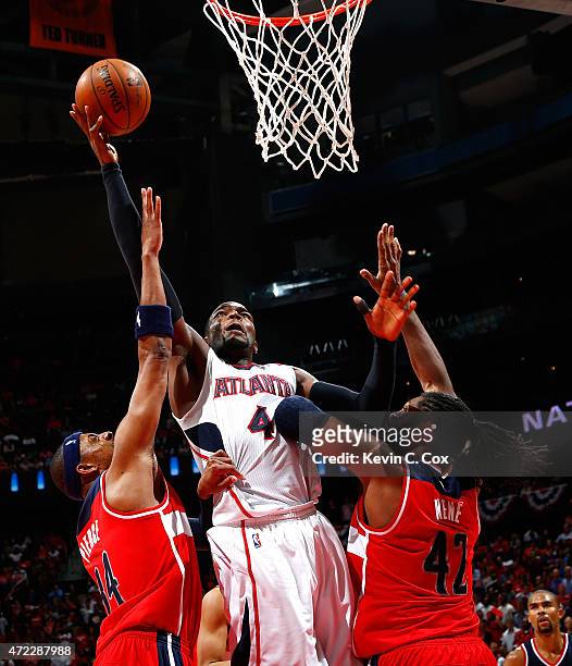 Paul Millsap of the Atlanta Hawks shoots against Paul Pierce and Nene Hilario of the Washington Wizards during Game Two of the Eastern Conference...