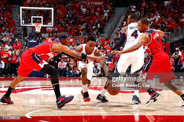 Jeff Teague of the Atlanta Hawks drives between Paul Pierce and Ramon Sessions of the Washington Wizards during Game Two of the Eastern Conference...