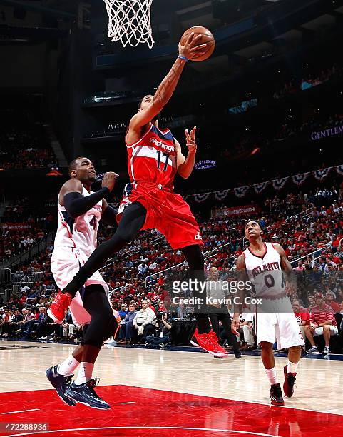Garrett Temple of the Washington Wizards drives against Paul Millsap and Jeff Teague of the Atlanta Hawks during Game Two of the Eastern Conference...